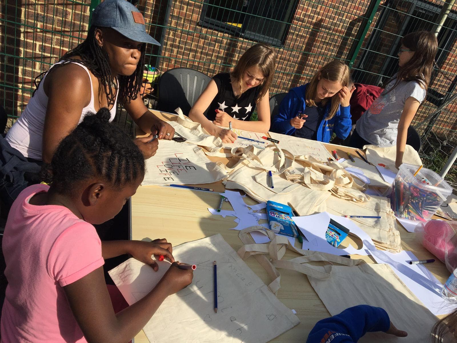 Young people and community members creating together at a workshop table